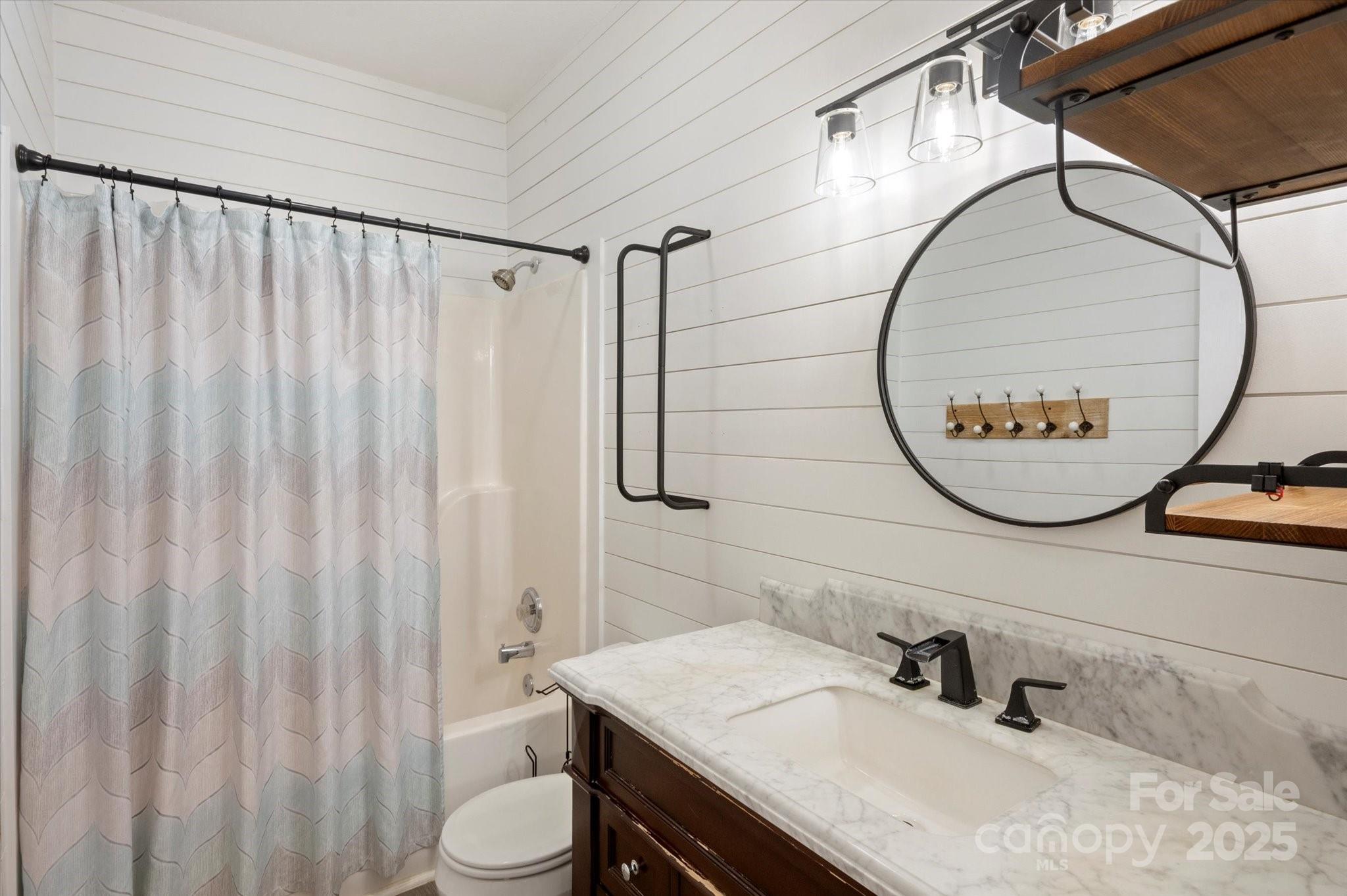 2409 Golf Course Road, Unit 14 Columbus, NC 28722 - Photo 20 of 25 a bathroom with a sink vanity mirror and a toilet