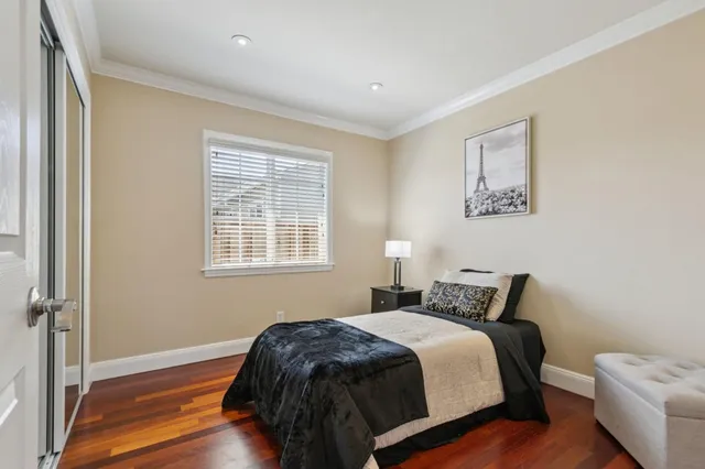 a bedroom with a bed and wooden floor