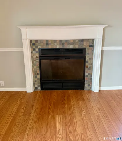 a view of empty room with wooden floor and fireplace