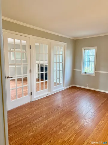 a view of empty room with wooden floor