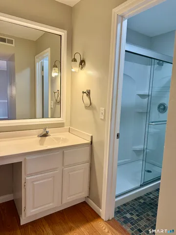 a bathroom with a granite countertop toilet and a shower