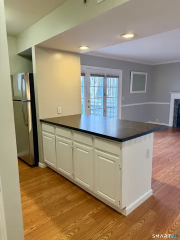 a kitchen with granite countertop cabinets and wooden floor