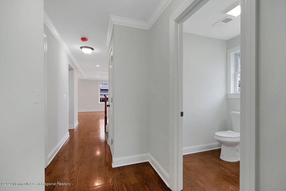 154 Pinehurst Road Brick, NJ 08723 - Photo 9 of 36 a view of a hallway with wooden floor and a bathroom