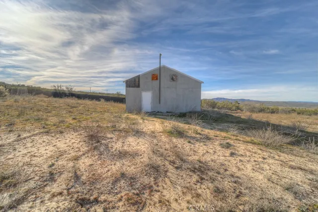 a view of a dry yard with wooden fence and a mountain view