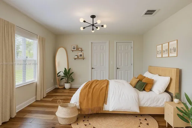 a view of a room with wooden floor and chandelier fan