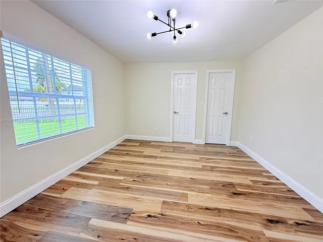 a view of a room with wooden floor and ceiling fan
