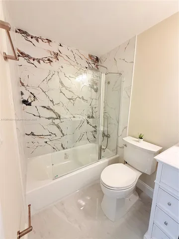 a bathroom with a bathtub sink mirror and toilet
