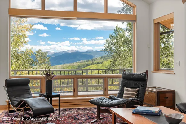a living room with furniture and a floor to ceiling window