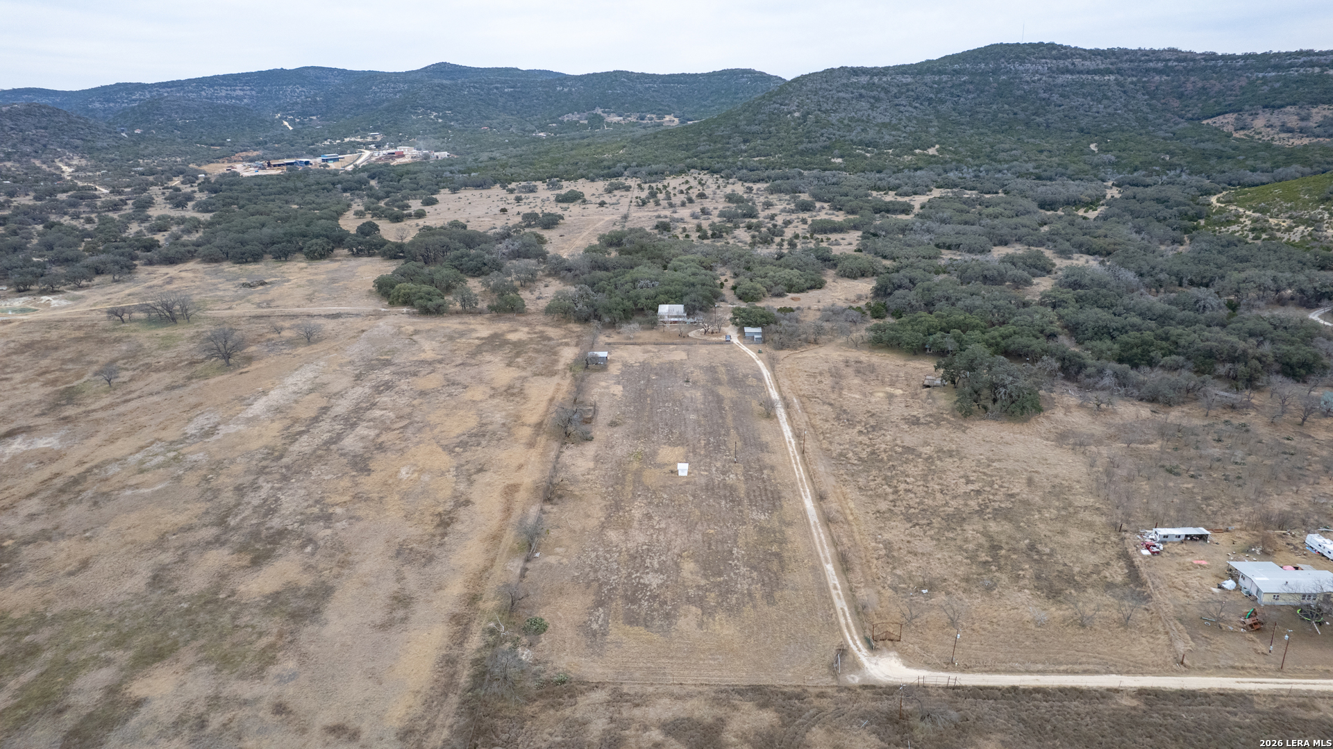 1674 Flat Rock Road Rio Frio, TX 78879 - Photo 36 of 39 a view of a dry yard with mountains in the background