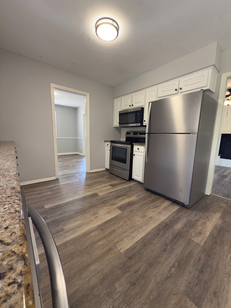 5829 Moon Road Columbus, GA 31909 - Photo 7 of 20 a view of kitchen with refrigerator stove and wooden cabinets