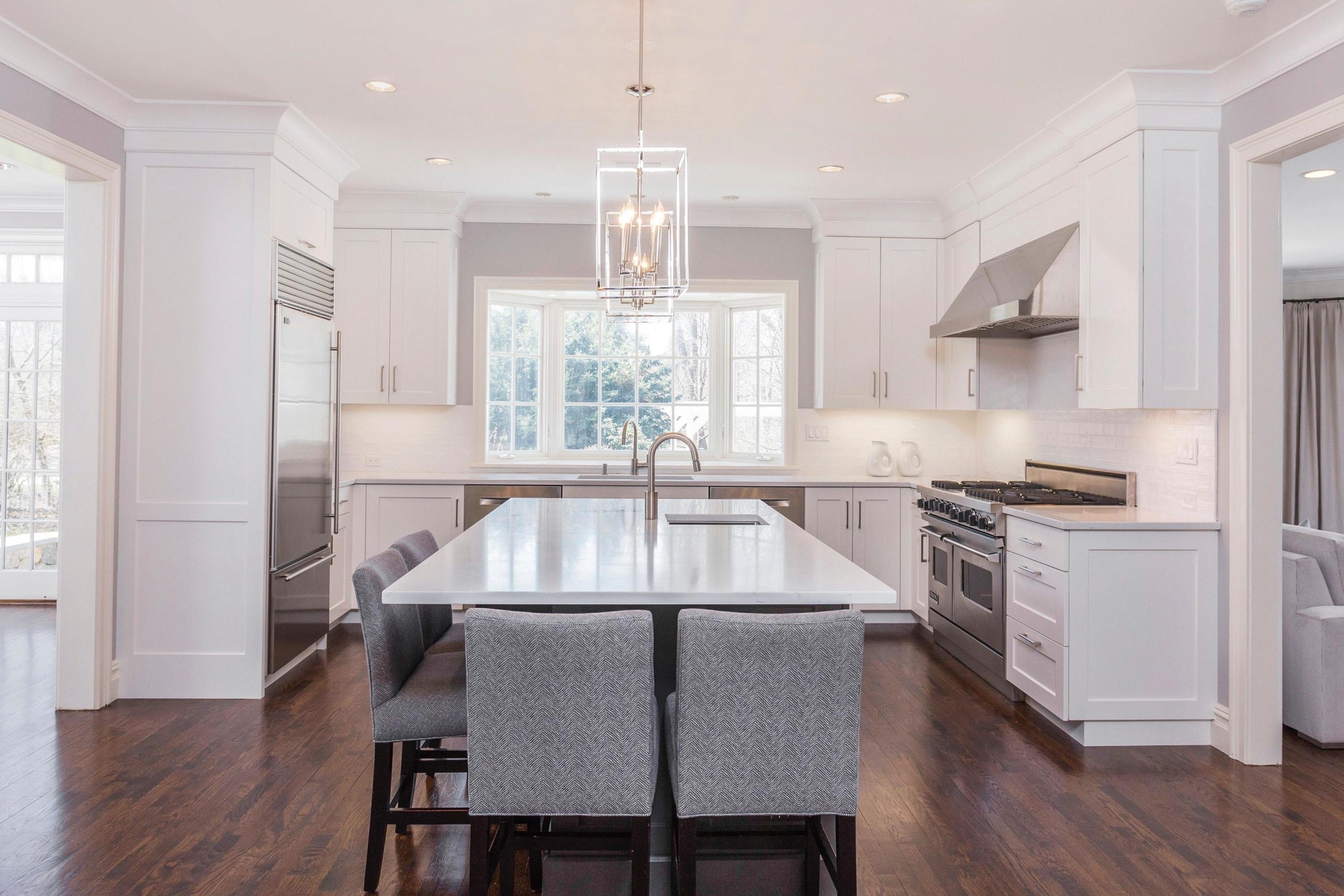 495 Hollow Tree Ridge Road Darien, CT 06820 - Photo 11 of 33 a kitchen with kitchen island a dining table chairs stainless steel appliances and windows