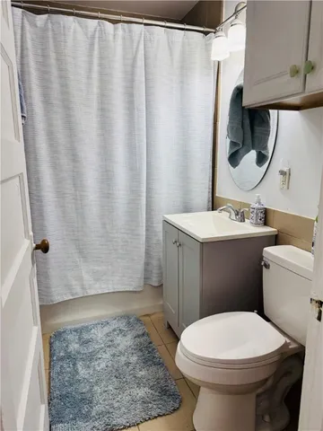 a bathroom with a sink a toilet and shower curtain