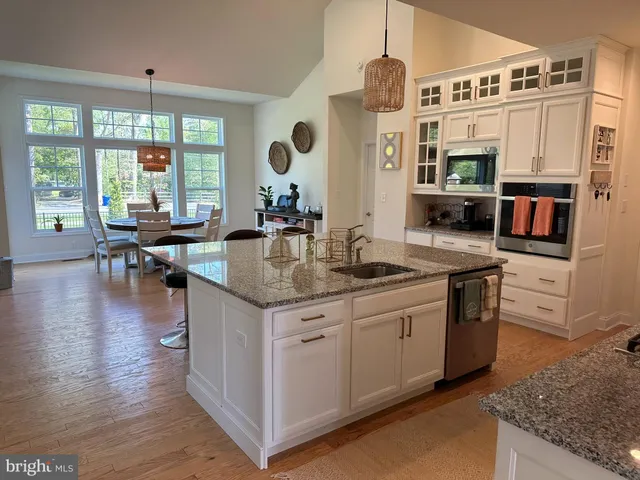 a kitchen with stainless steel appliances granite countertop a stove a kitchen island a table and chairs