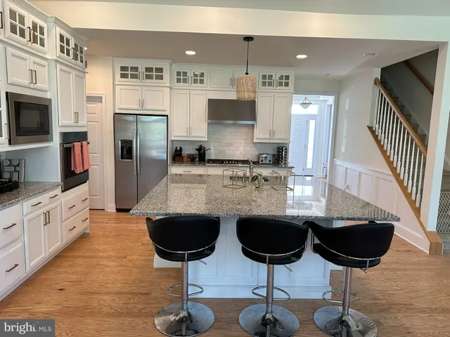 a kitchen with stainless steel appliances granite countertop a stove top oven a sink a counter space and cabinets