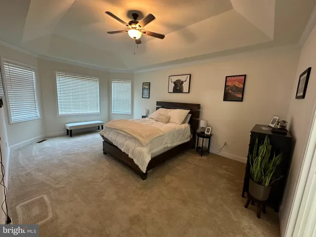 a spacious bedroom with a bed and a flat screen tv