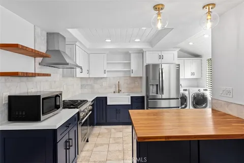 a kitchen with kitchen island a counter top a stove a refrigerator and cabinets