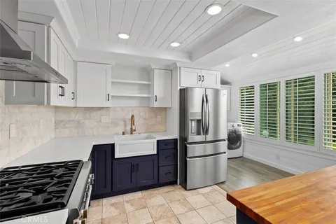 a kitchen with stainless steel appliances granite countertop a stove a sink dishwasher a refrigerator and cabinets with wooden floor