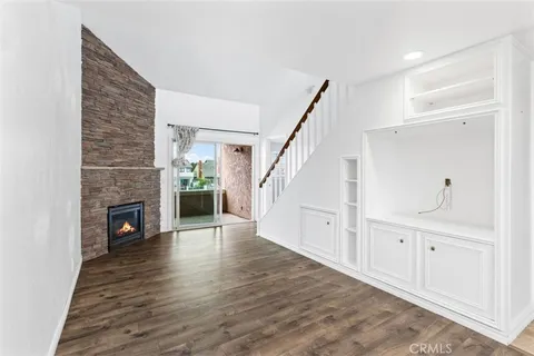 a view of a livingroom with wooden floor and a fireplace