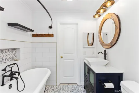 a bathroom with a granite countertop sink a toilet and shower