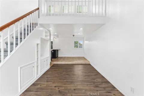 a view of a hallway with wooden floor and staircase