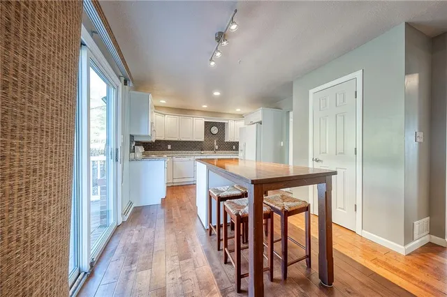 a kitchen with stainless steel appliances granite countertop wooden floor window and cabinets