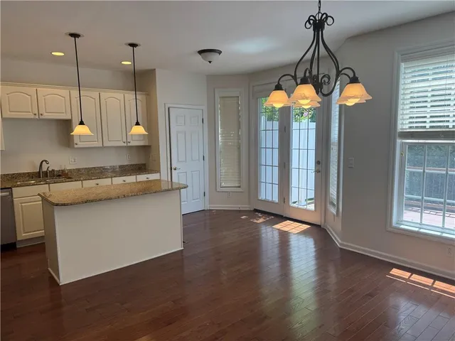 a view of a kitchen with a ceiling fan wooden floor and a window
