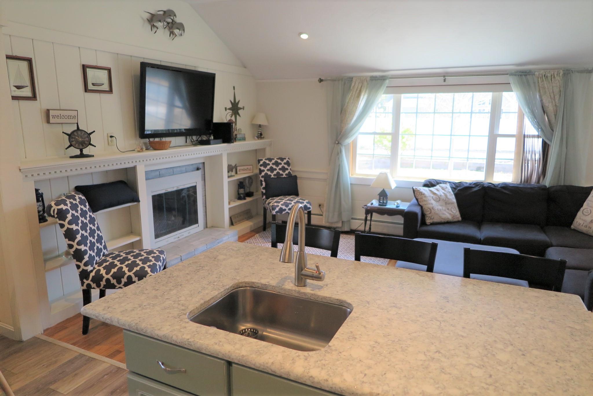 25 Susan Ruth Road Dennis Port, MA 02639 - Photo 12 of 40 a living room with furniture a flat screen tv and a large window