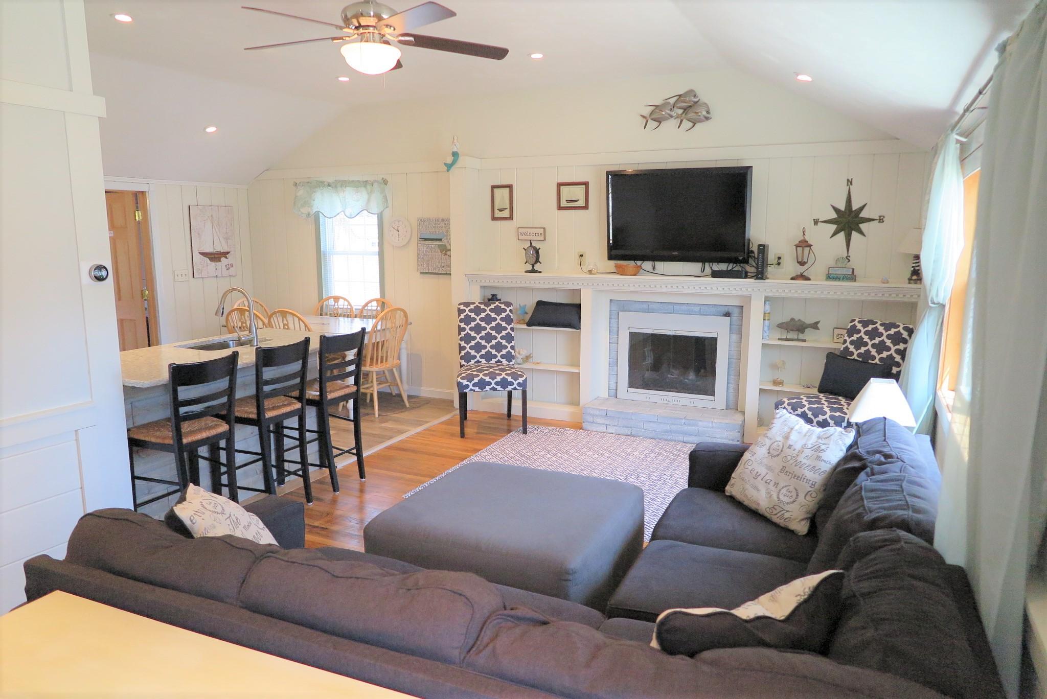 25 Susan Ruth Road Dennis Port, MA 02639 - Photo 3 of 40 a living room with furniture a fireplace and a flat screen tv