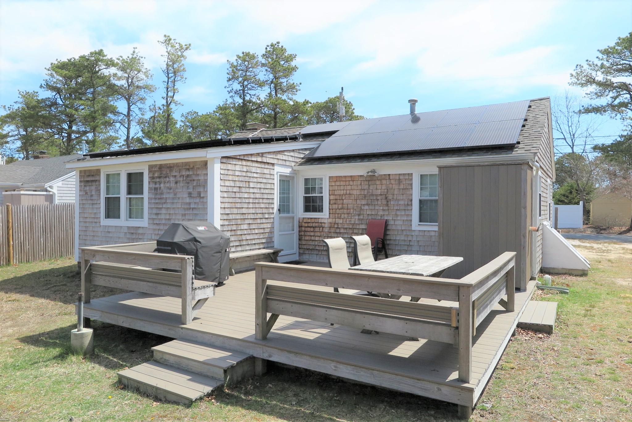 25 Susan Ruth Road Dennis Port, MA 02639 - Photo 31 of 40 a view of a patio with table and chairs with wooden floor and fence