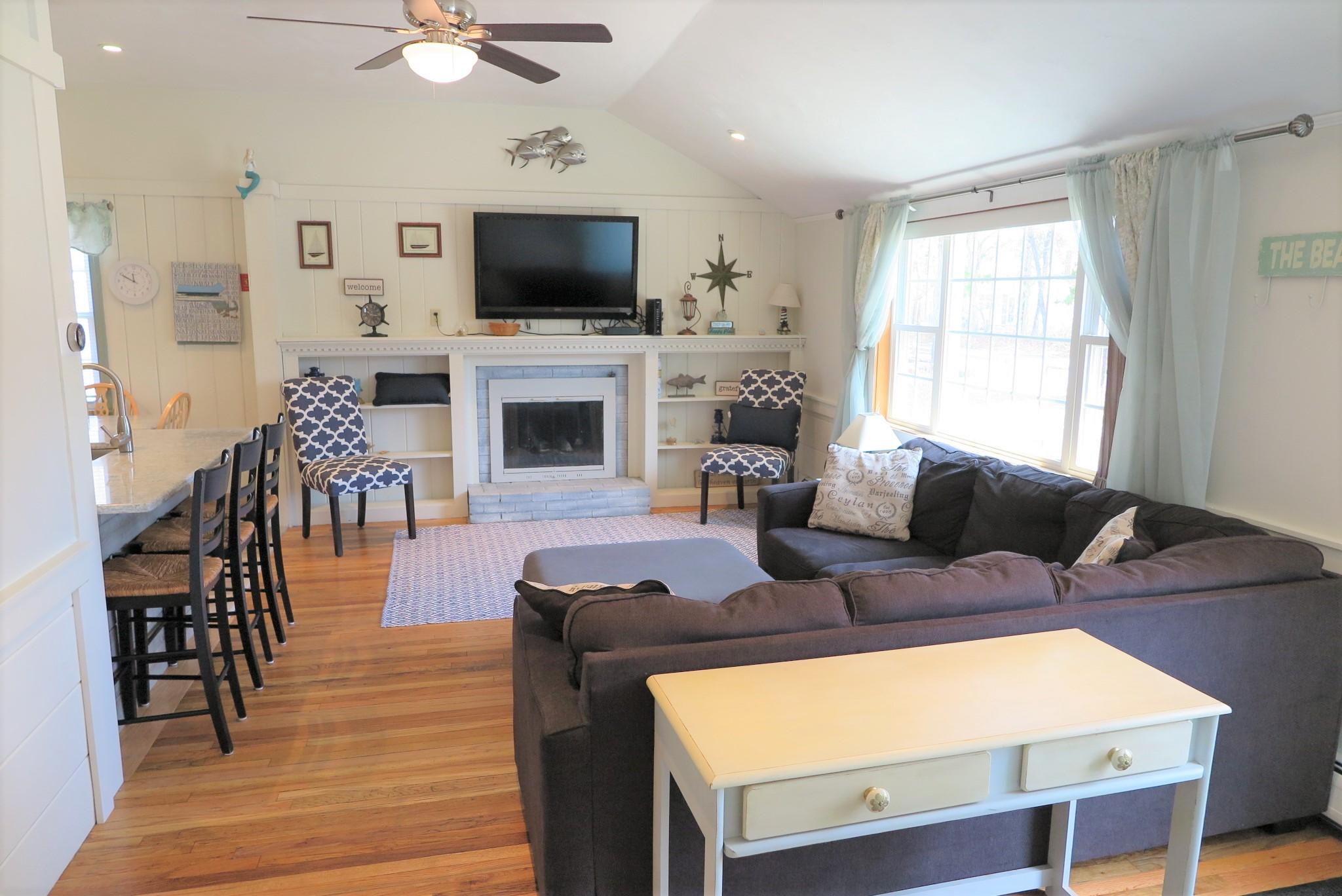 25 Susan Ruth Road Dennis Port, MA 02639 - Photo 4 of 40 a living room with furniture a fireplace and a flat screen tv