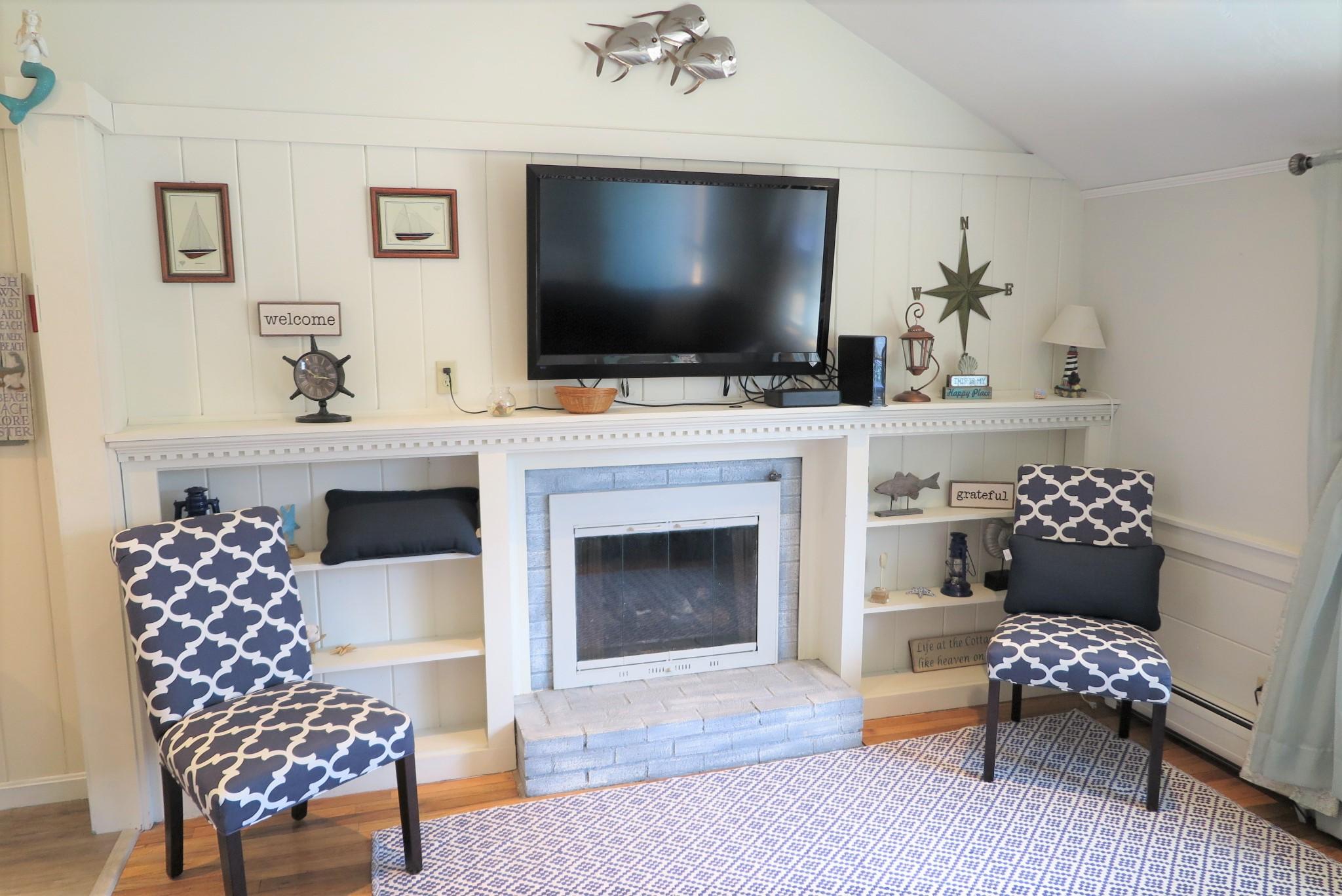 25 Susan Ruth Road Dennis Port, MA 02639 - Photo 6 of 40 a living room with furniture a flat screen tv and a fireplace