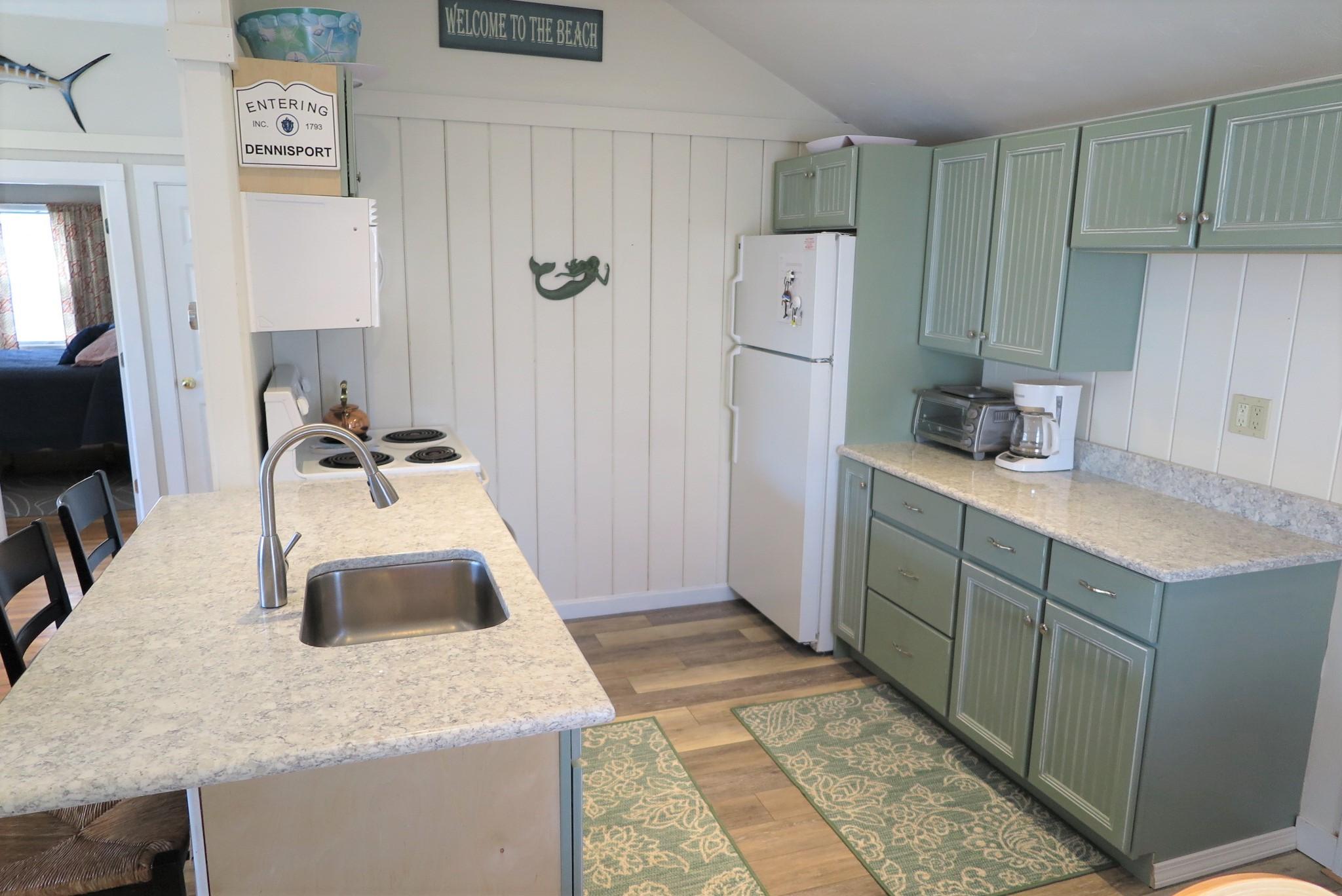 25 Susan Ruth Road Dennis Port, MA 02639 - Photo 9 of 40 a kitchen with a sink a stove and refrigerator