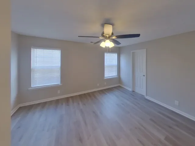 wooden floor in an empty room with a window