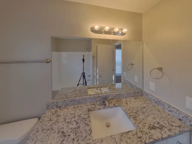 a view of a hallway to room with wooden floor