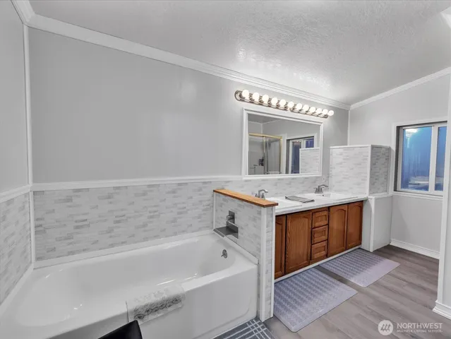 a bathroom with a tub sink and mirror