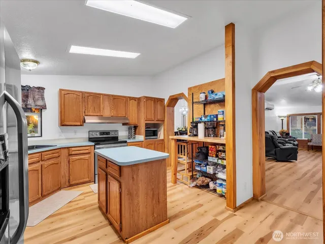 a kitchen with stainless steel appliances granite countertop a stove top oven a sink and a refrigerator