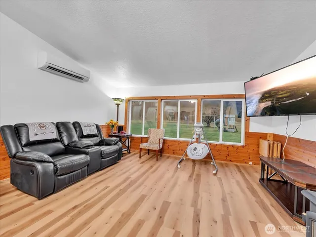 a living room with furniture a flat screen tv and a large window