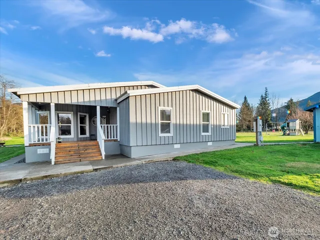 a view of a house with a yard and sitting area