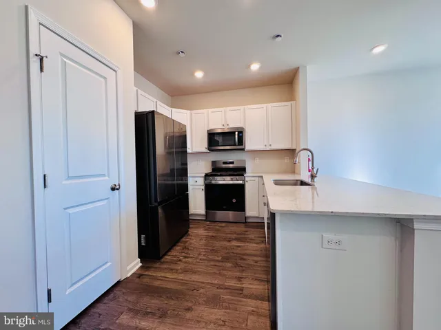 a kitchen with kitchen island a counter top space stainless steel appliances and cabinets