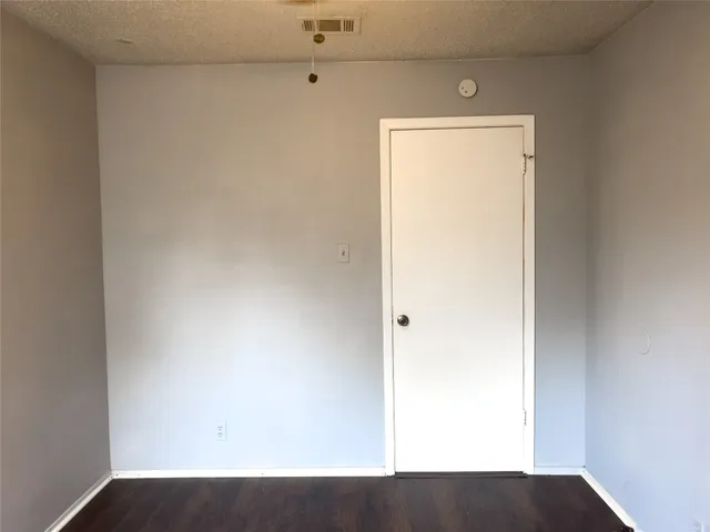 a view of a small space with wooden floor and a window