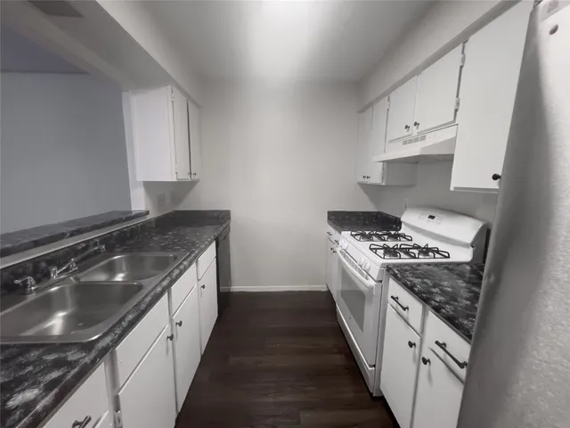 a kitchen with granite countertop a stove and a sink