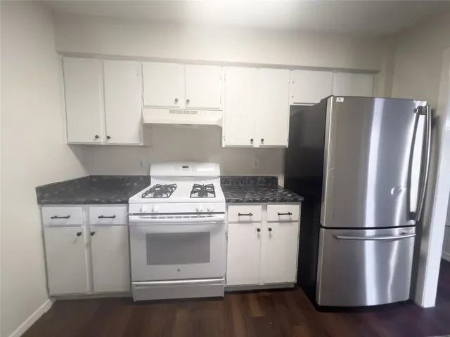 a kitchen with a stove top oven and refrigerator