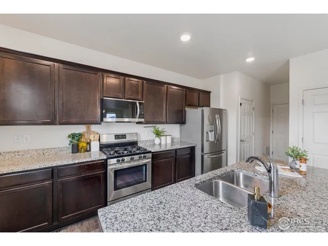 a kitchen with stainless steel appliances a refrigerator and a stove top oven