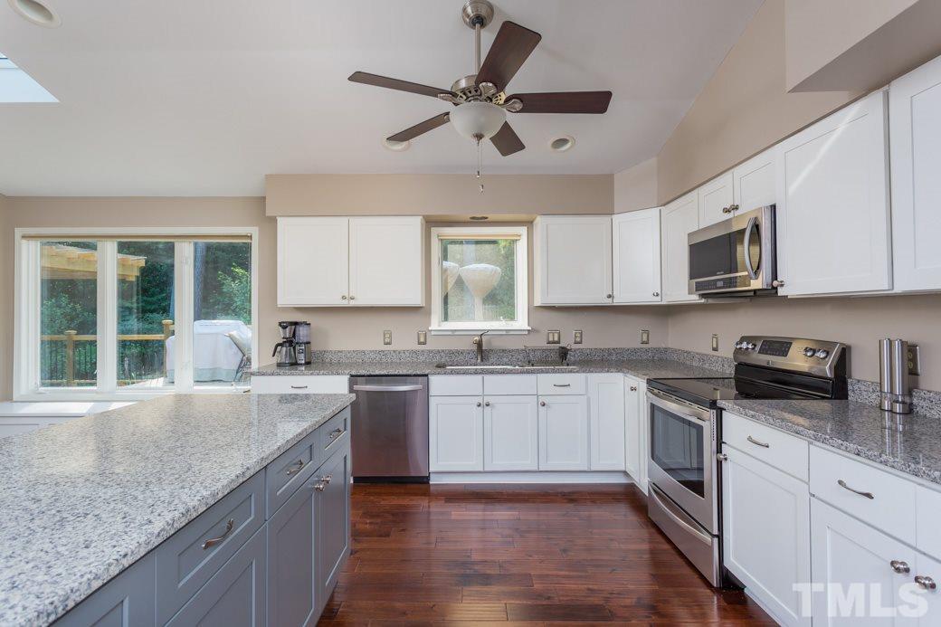 4213 Tolchester Place Raleigh, NC 27613 - Photo 2 of 25 a kitchen with granite countertop cabinets stainless steel appliances a sink and a window