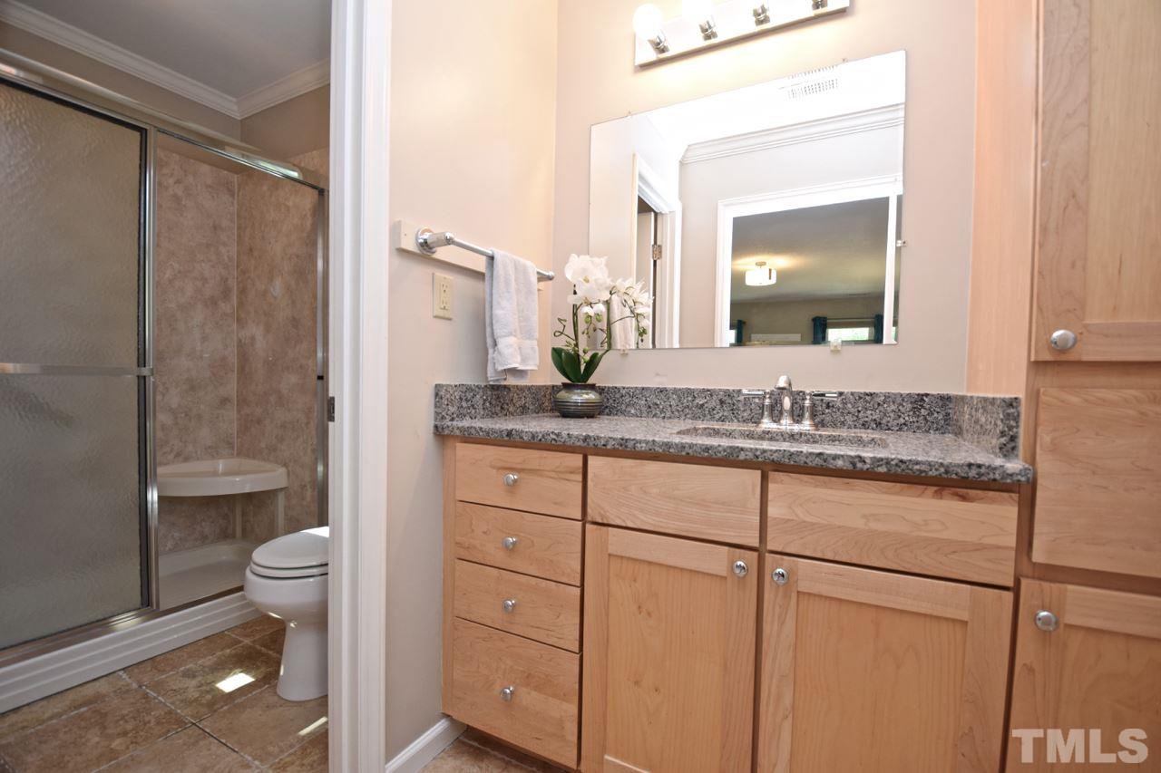 4213 Tolchester Place Raleigh, NC 27613 - Photo 14 of 25 a bathroom with a granite countertop sink toilet and shower