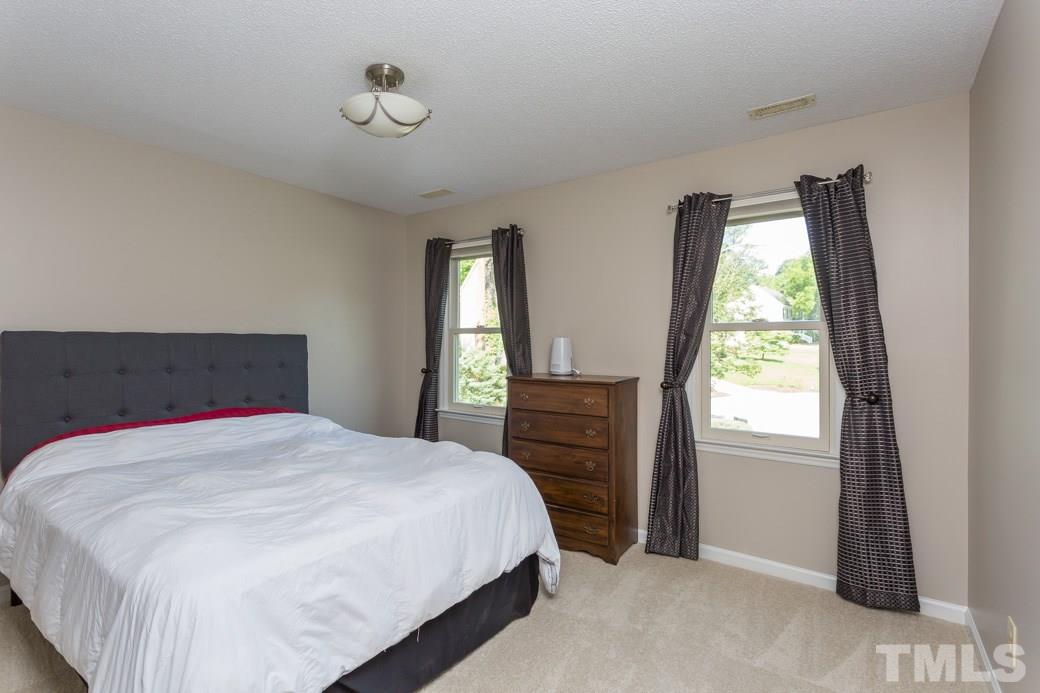 4213 Tolchester Place Raleigh, NC 27613 - Photo 15 of 25 a bedroom with a bed and a window