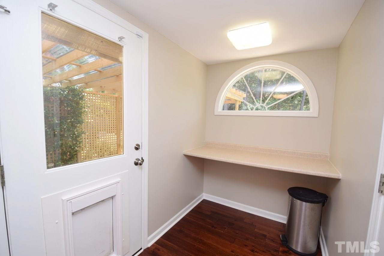 4213 Tolchester Place Raleigh, NC 27613 - Photo 18 of 25 a view of an empty room with wooden floor and a window