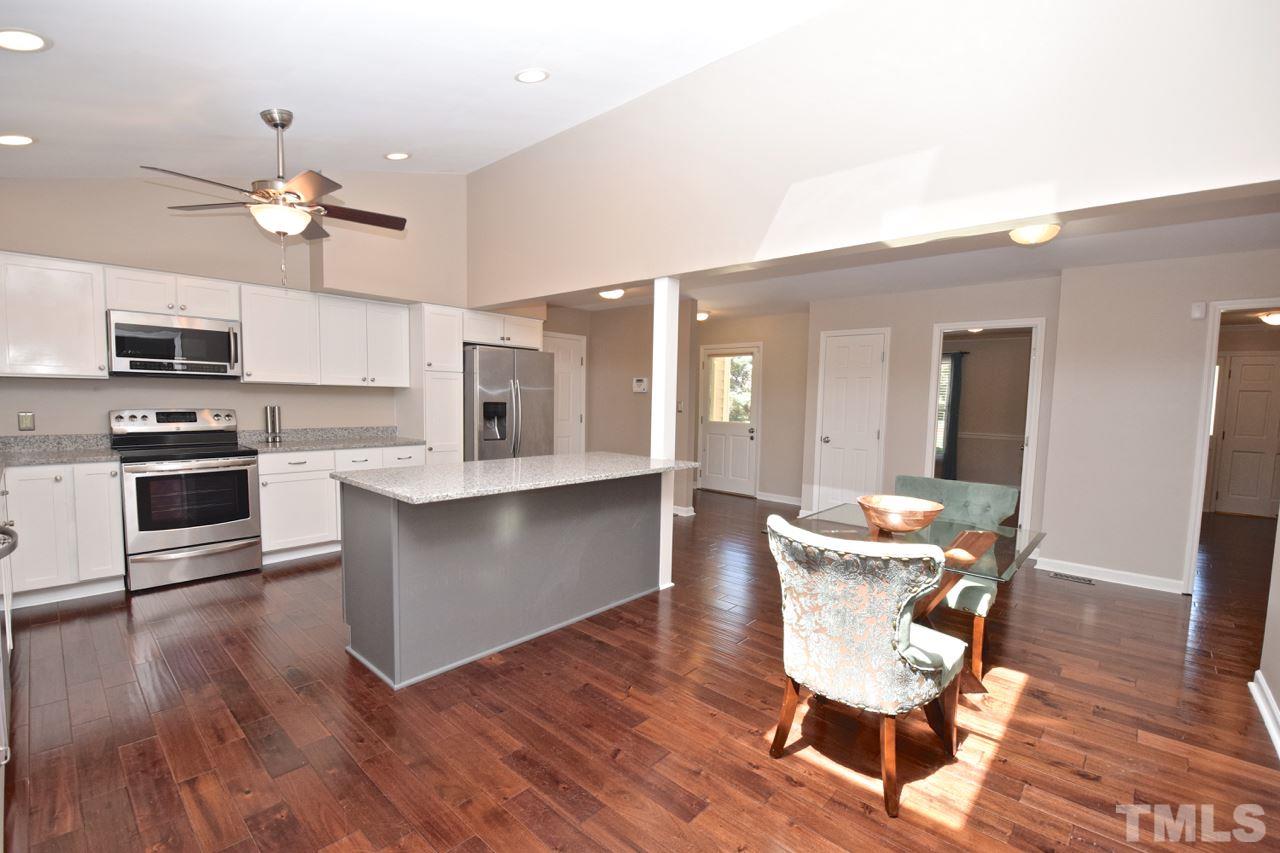4213 Tolchester Place Raleigh, NC 27613 - Photo 3 of 25 a view of a dining room with furniture wooden floor and chandelier