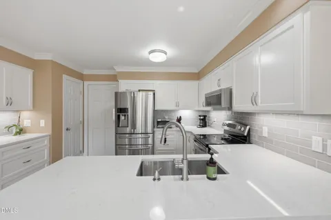 a kitchen with white cabinets and stainless steel appliances