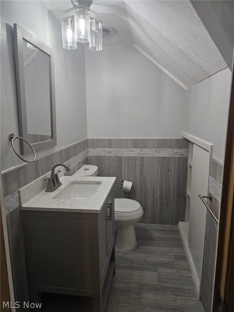 4237 Stonehaven Road South Euclid, OH 44121 - Photo 32 of 35 Vanity with a light-toned countertop, modern brushed nickel faucet, wall-mounted rectangular mirror, and wood-look tile flooring